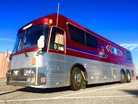 a red and blue bus parked in a parking lot