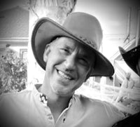 two men in cowboy hats smiling for the camera